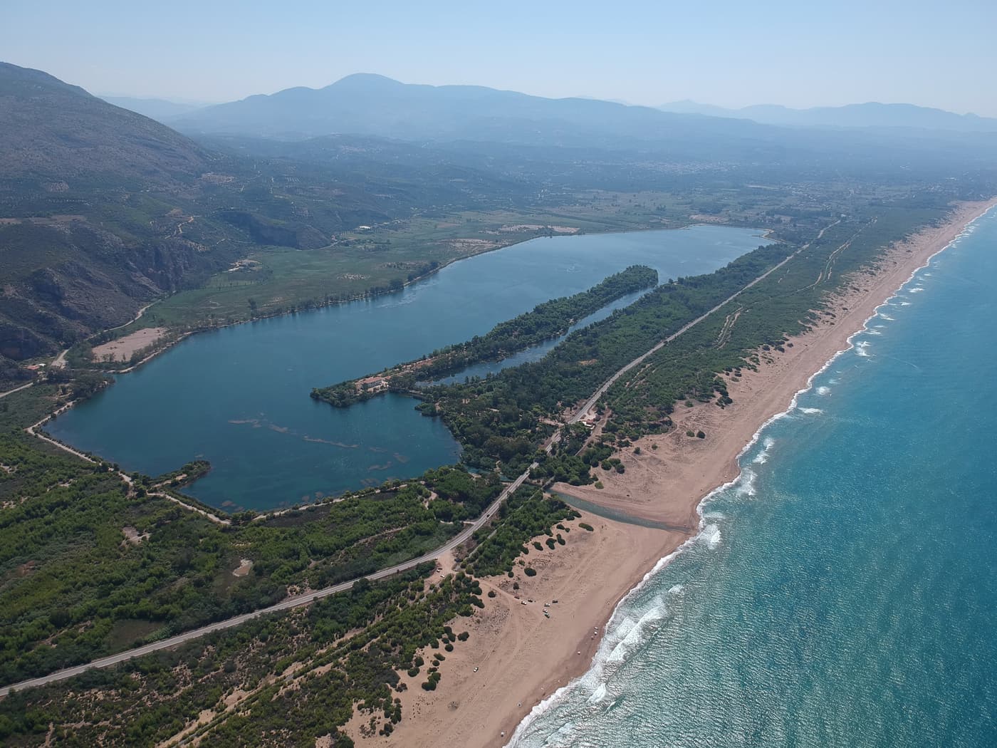 Aerial view of Kaiafas Lake, its pine forest and the long beach on the Ionian coast