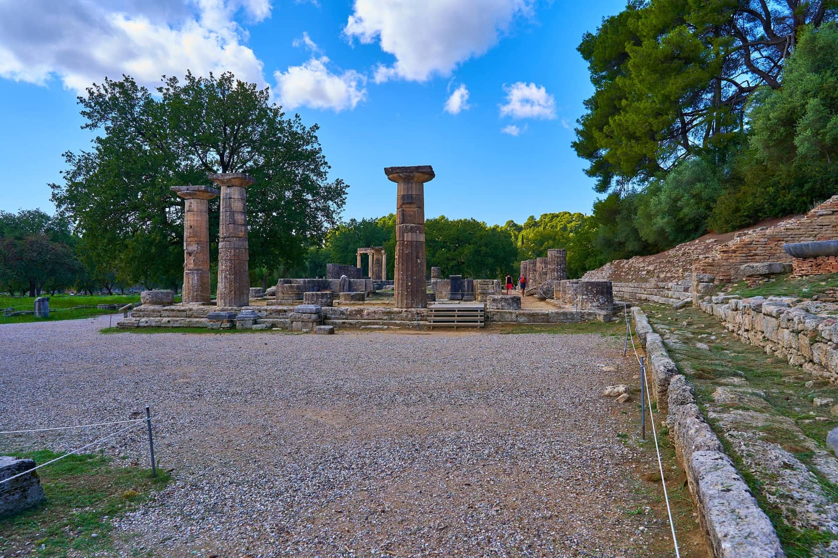 The columns of the Temple of Hera at Ancient Olympia under a blue sky